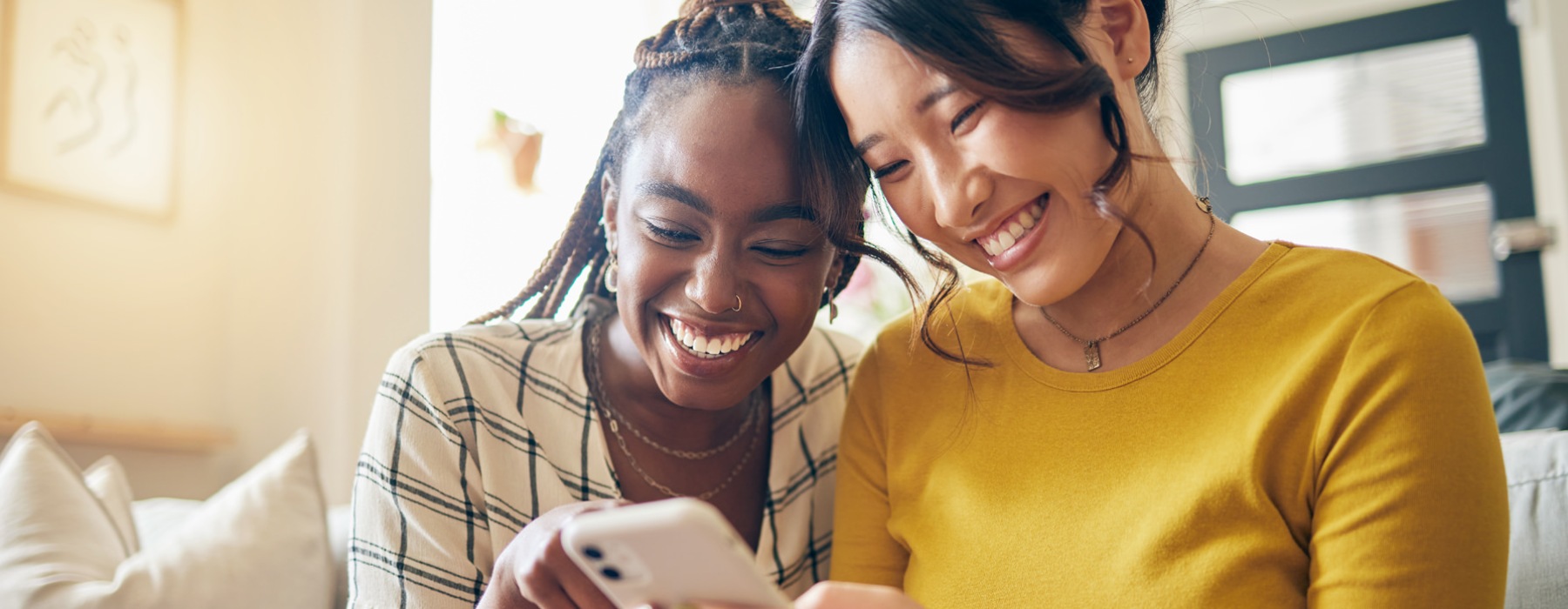 two women smiling looking at a device