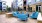 a group of blue lounge chairs on a deck in front of a building