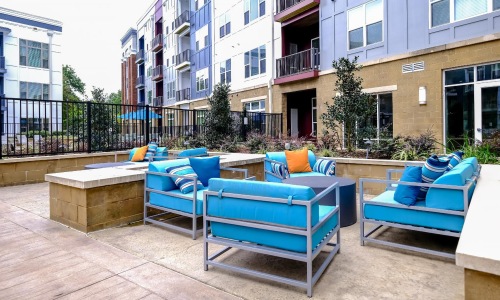 a group of blue lounge chairs on a deck in front of a building